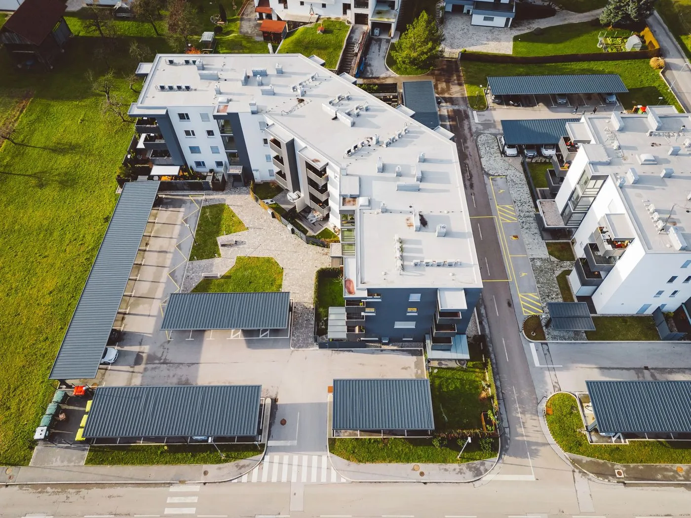 Laden im Mehrparteienhaus – Luftaufnahme Wohngebäude mit Stellplätzen